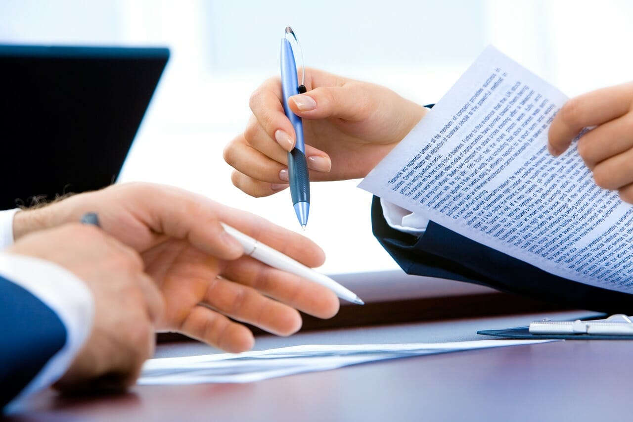 Business Setting with Hands Gesturing Over Documents - Benefits of Clarifying German Pension Account